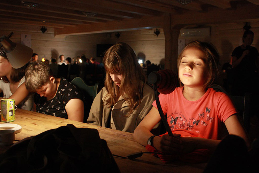 Adjusting to the dark and to the light. Children using lamps to move from darkness to light.